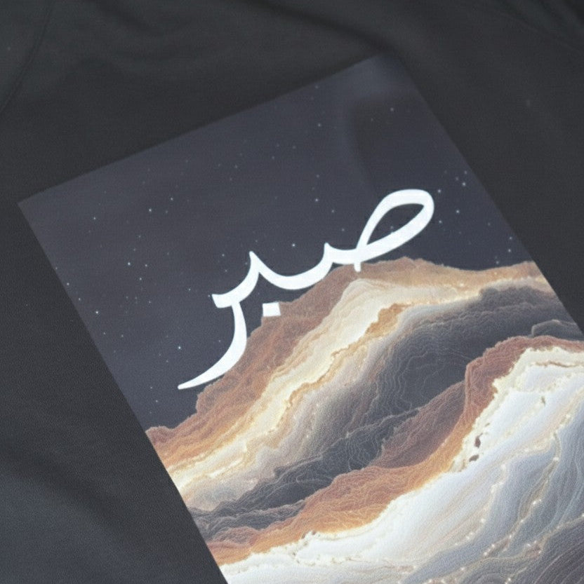 Black jacket with a mountain landscape design and white text on a dark background