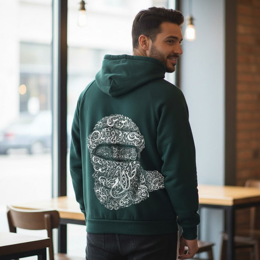 Man wearing a green hoodie with a white graphic design in a casual setting